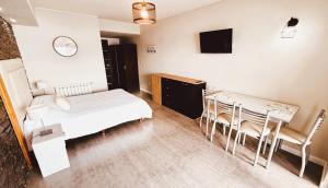 a bedroom with a bed and a table and chairs at Departamento a Orilla del Lago in San Carlos de Bariloche