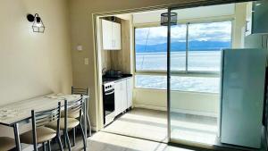 a kitchen with a table and a refrigerator and a window at Departamento a Orilla del Lago in San Carlos de Bariloche +17 photos