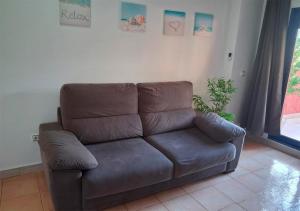 a brown leather couch sitting in a living room at Apartalux de la Manga II in La Manga del Mar Menor +27 photos
