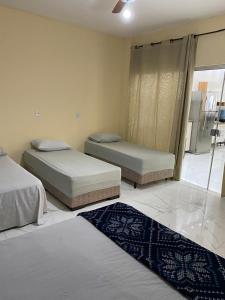 zwei Betten in einem Zimmer mit zwei Teppichen auf dem Boden in der Unterkunft Casa Colorado Thermas Laranjais Olimpia in Olímpia