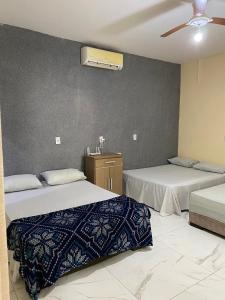 ein Schlafzimmer mit zwei Betten und einem Deckenventilator in der Unterkunft Casa Colorado Thermas Laranjais Olimpia in Olímpia
