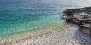 an aerial view of a rocky beach with the ocean at Anassa Mare Villas & Residences by GHH in Gaios