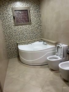 a bathroom with a tub and a toilet in it at Villa iligh in Agadir +16 photos