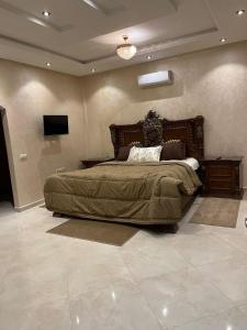 a bedroom with a large bed and a television at Villa iligh in Agadir