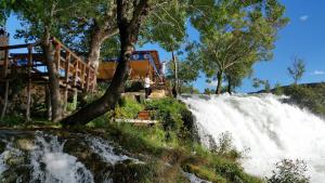 una persona in piedi sul lato di una cascata di Studio Apartment Maslina a Gornji Karin (Carino)