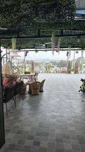 a large patio with chairs and tables and plants at Sky homestay in Dehradun