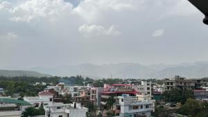 a city with buildings and mountains in the background at Sky homestay in Dehradun
