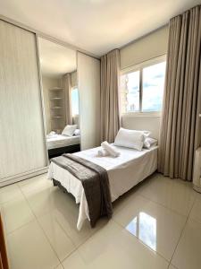 a bedroom with a bed and a large window at Davisis Luxo - Dunas do Jalapão Centro e Av JK in Palmas +30 photos