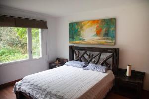 a bedroom with a bed and a painting on the wall at Villa in the Forest - Mont Ventoux in Cali