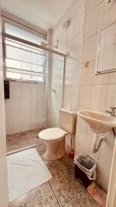 un baño con inodoro y lavabo en Suíte 300 Pitangueiras - na quadra da praia, en Guarujá 16 fotos más
