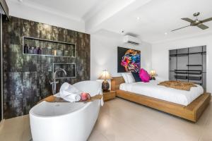a bedroom with a large bed and a bath tub at Belle Escapes Chillandos in Smithfield +82 photos
