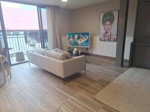 Una sala de estar con un sofá y una ventana grande. en Casco View-Boutique Studio-New Building, en Panamá