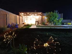 Un patio trasero de noche con un cobertizo con luces. en Lamora, en La Criolla