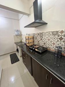 a kitchen with a counter top and a stove at Flat in Manipal cozy corner in Manipala