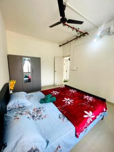 a bedroom with a large bed with a red blanket at Flat in Manipal cozy corner in Manipala