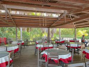 a restaurant with tables and chairs and a person sitting on a porch at Apto para 6 pessoas no melhor resort dos Lençóis in Barreirinhas