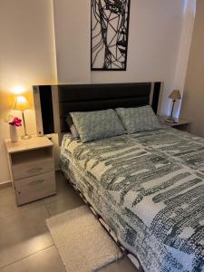 une chambre avec un lit et une table de chevet avec une lampe dans l'établissement Paseo Quattro Villa Carlos Paz, à Villa Carlos Paz