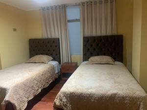 a bedroom with two beds and a window at Hospedaje San Blas in San Antonio