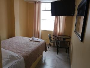 a bedroom with a bed and a table and a window at Hospedaje San Blas in San Antonio