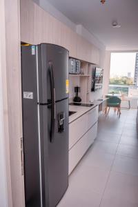 a kitchen with a stainless steel refrigerator in a room at Porto Horizonte Suite 735 in Santa Marta