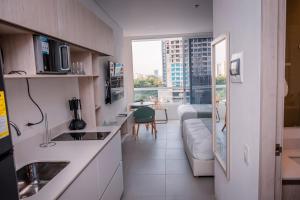 a kitchen with a couch and a living room at Porto Horizonte Suite 735 in Santa Marta