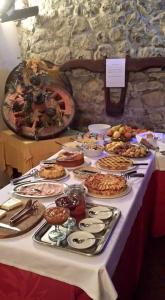una mesa con muchos tipos diferentes de comida en ella en Agriturismo La Fenice, en Tolè