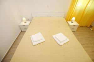 2 Betten mit weißen Kissen auf einem Zimmer in der Unterkunft Holiday Home Zemljak in Sukošan