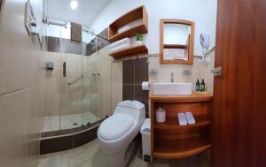 a bathroom with a toilet and a sink and a shower at CASA GALAPAGOS by Hostal Fragata in Puerto Ayora +15 photos