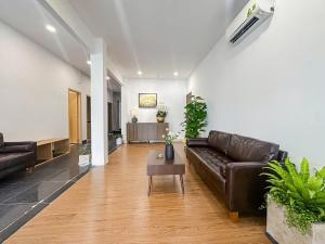 a living room with a leather couch and a table at The Cozy Nest in Ho Chi Minh City