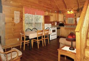 a kitchen and dining room with a table in a cabin at Jon's Pond on Cosby Creek in Cosby