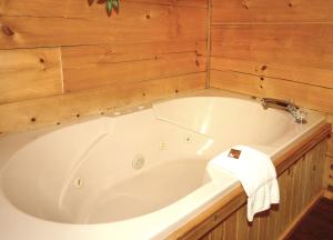 a large white bath tub in a wooden bathroom at Jon's Pond on Cosby Creek in Cosby