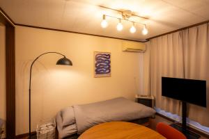 a bedroom with a bed and a flat screen tv at BREEZE furano Annex205 in Furano