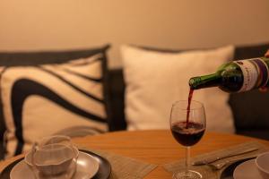 a person pouring red wine into a glass on a table at BREEZE furano Annex205 in Furano +63 photos