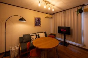 a living room with a table and a couch at BREEZE furano Annex205 in Furano