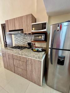 a kitchen with a stainless steel refrigerator and a microwave at Loft Yol-Kin Bacalar in Bacalar +5 photos