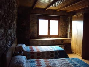 una camera da letto con due letti e una finestra di Casa de Lucas a Fonfría Altre 37 foto