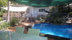 a swimming pool in a yard with a table and chairs at Del Haven Holiday House in Arcadia