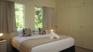a bedroom with a large bed with two windows at Del Haven Holiday House in Arcadia +11 photos
