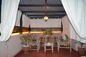 un comedor con mesas, sillas y cortinas en Golden Palms Marrakech, en Marrakech 37 fotos más