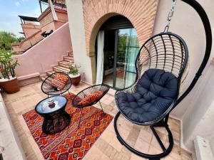 a patio with a swing chair and a table at Golden Palms Marrakech in Marrakesh