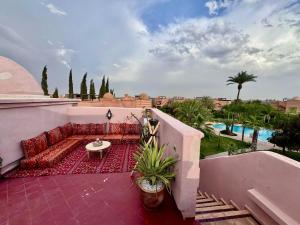 Un patio con un sofá y una mesa en un balcón. en Golden Palms Marrakech, en Marrakech