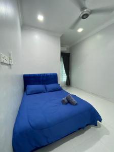 a bed in a white room with a blue blanket at Tok Jiring Boutique Homestay in Kuala Terengganu +14 photos
