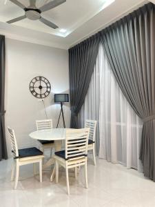 a dining room with a table and chairs and a clock at Tok Jiring Boutique Homestay in Kuala Terengganu