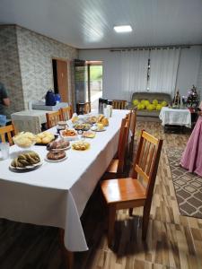 a long table with plates of food on it at Pousada Bella Montanha in Louro Müller