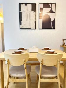 a wooden table with two chairs and a table with bowls on it at SplashMania Gamuda Cove in Banting +12 photos