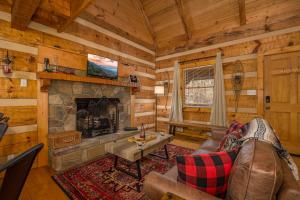 a living room with a fireplace in a log cabin at Hidden Hideaway in Cosby