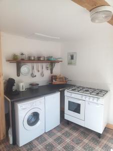 a kitchen with a stove and a washing machine at Maison de Polly in Saint-Gaultier