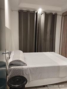 a small bedroom with a bed with white sheets at Mi casa su casa 3 in Londrina +11 photos