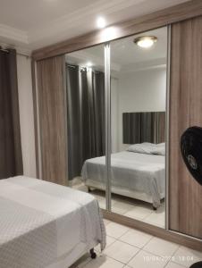 a bedroom with two beds and a mirror at Mi casa su casa 3 in Londrina
