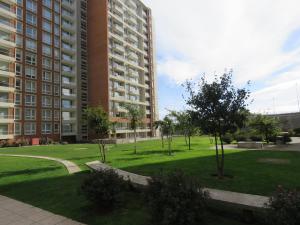 a park in front of a large apartment building at Concepción Suites in Concepción